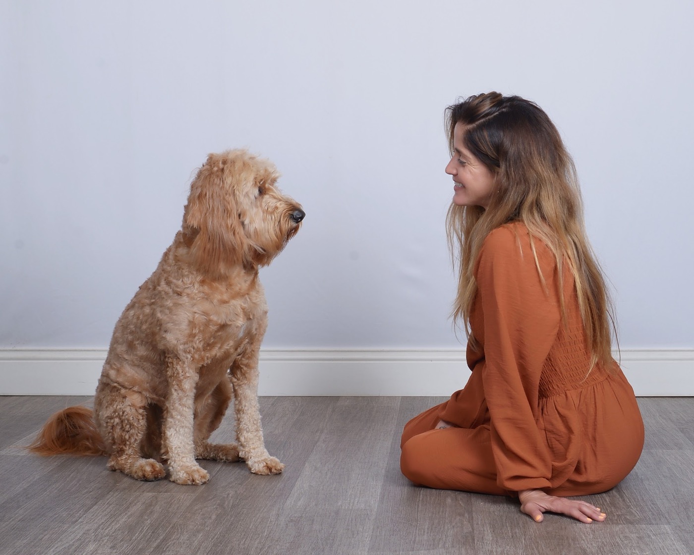 Lauren Pena and Peach the Goldendoodle sitting together at the Inquisitive Canine shoot